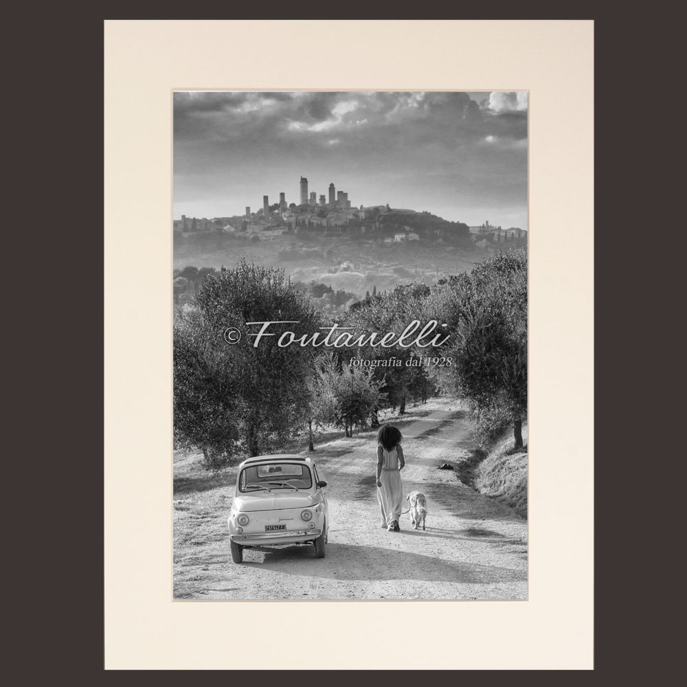Foto di Fiat 500 con Donna e cane sullo sfondo Di San Gimignano Toscana