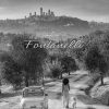Foto di Fiat 500 con donna e cane sullo sfondo di San Gimignano, Toscana